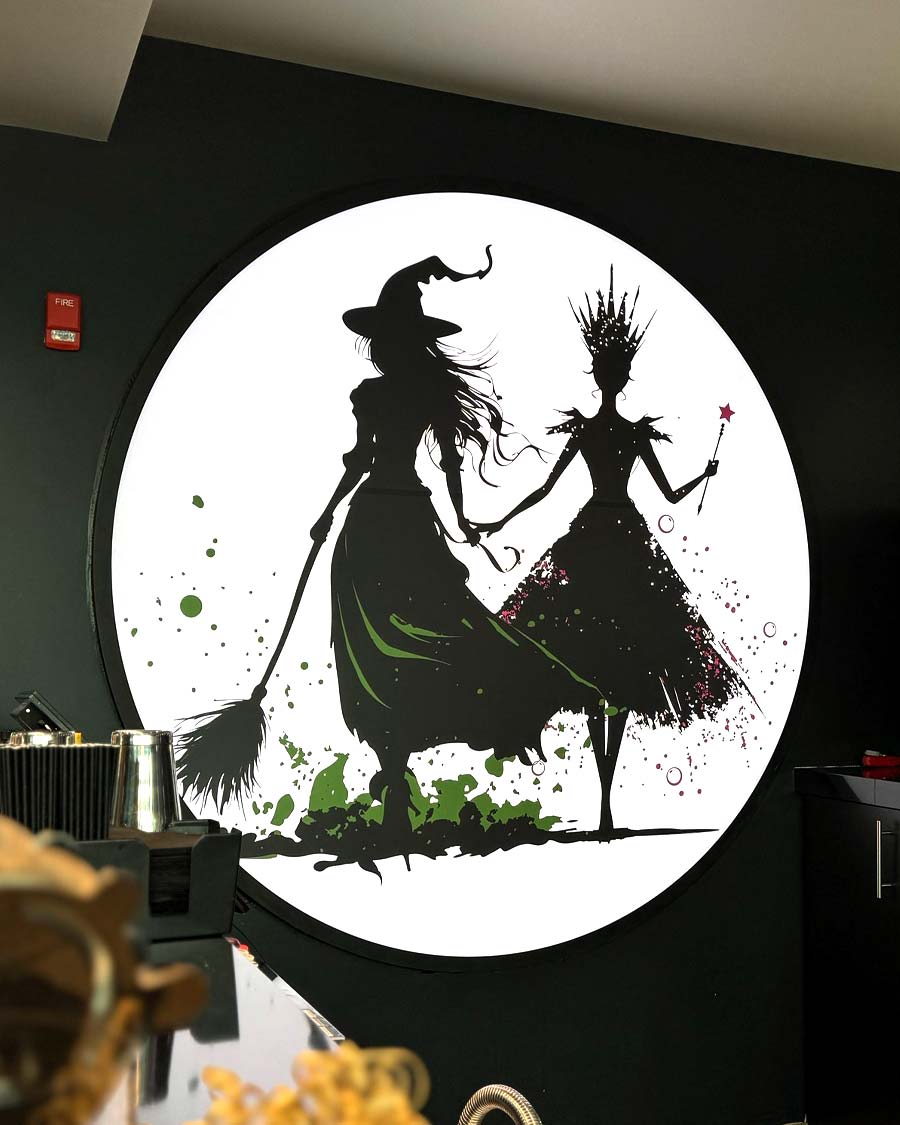 Wicked promo graphic on the wall at Penn Cinema
